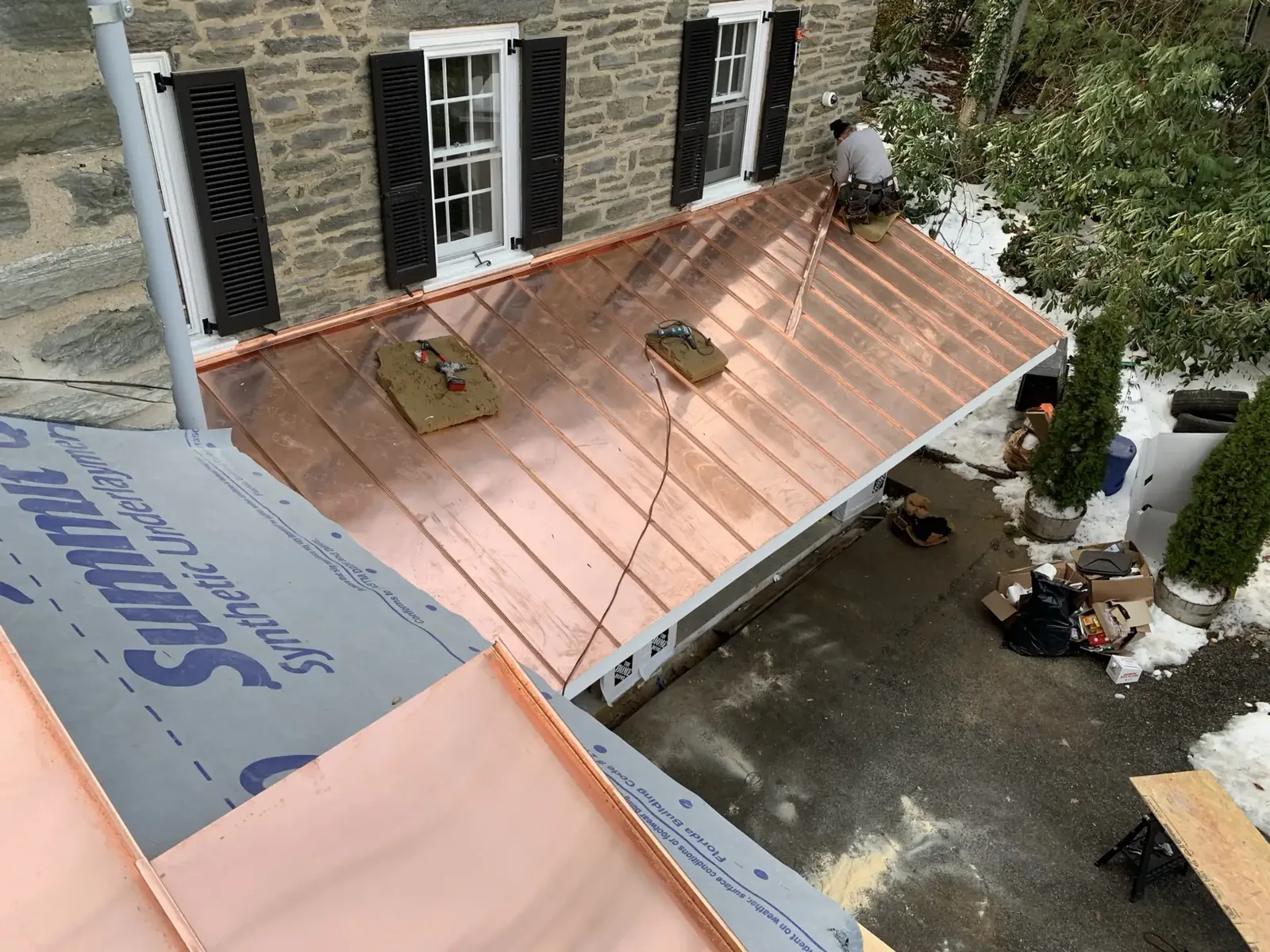 Copper roof installation on a stone home